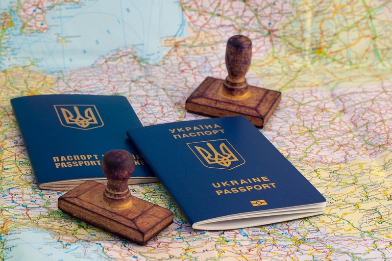 Two Ukrainian passports, stamps of border crossing and map of Europe